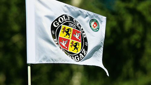 Eine weisse Fahne mit dem Logo des Golf Club Bad Ragaz in schwarz, rot und gelb.